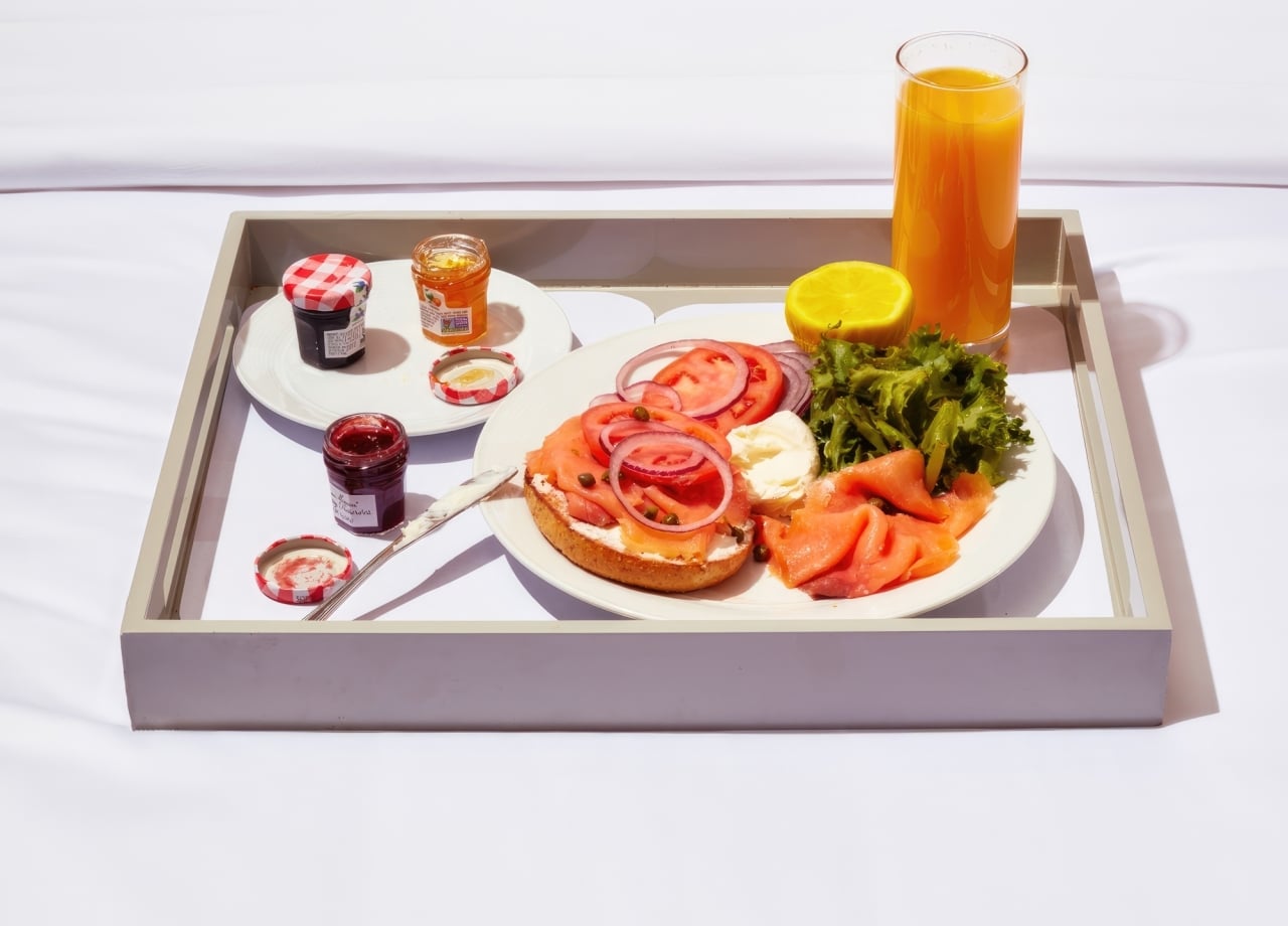 A breakfast tray with a plate of food and a glass of orange juice