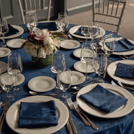 A table set with china, cutlery and glasses for an event.