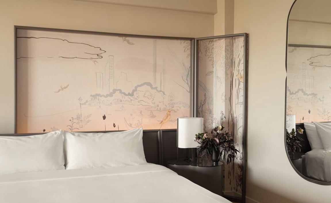 A king bed and painted mural in a suite at Park Lane New York.