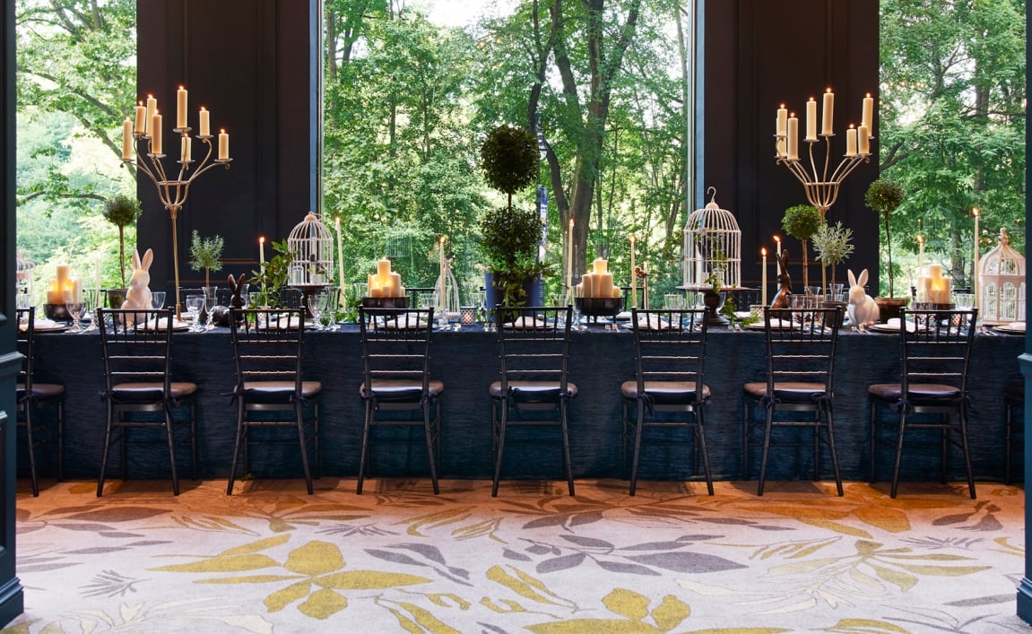 An elegant dining room with views of lush green outside.
