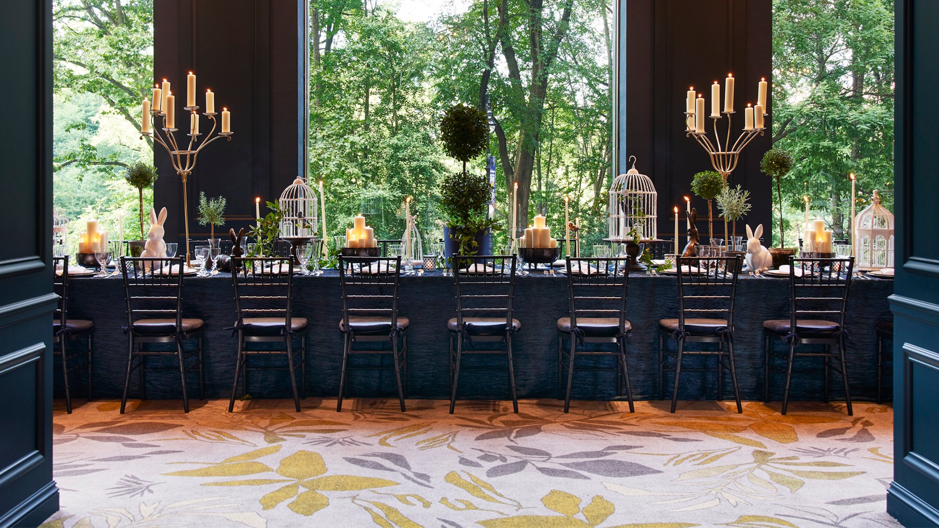 An elegant dining room with views of lush green outside.