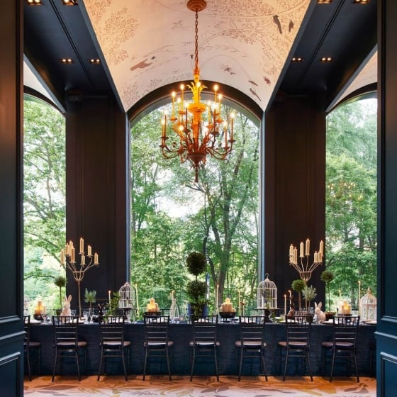 An elegant dining room with views of lush green outside.