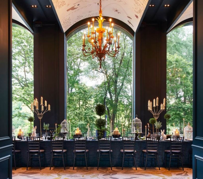 An elegant dining room with views of lush green outside.