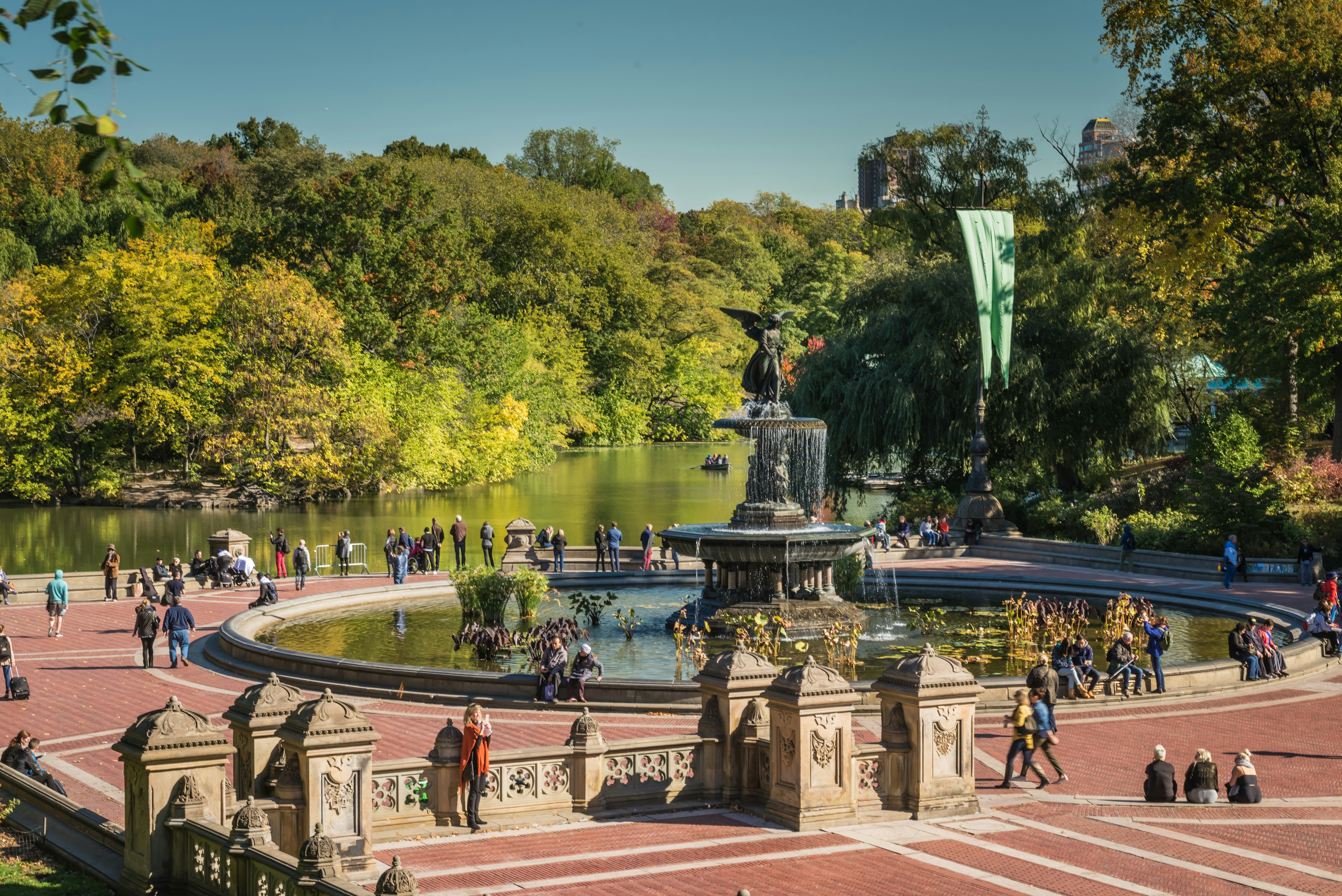 a large public park with a statue and lake